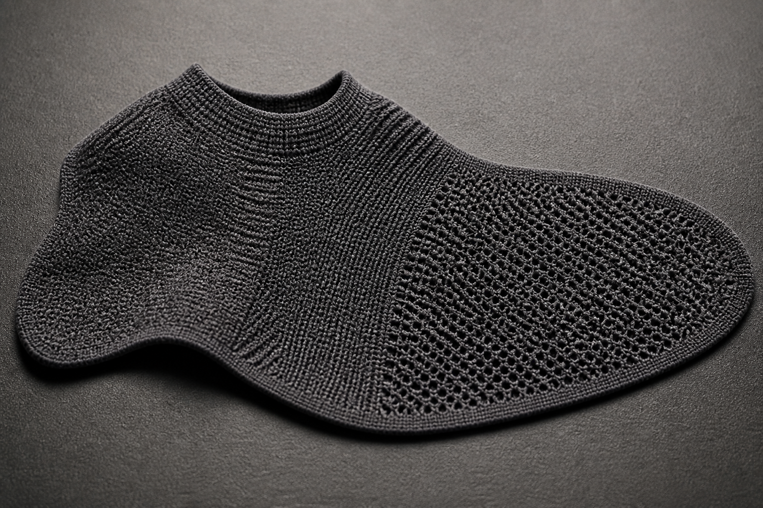 Macro view of a seamless one-piece knit shoe upper showing no cut edges and no sewn seams